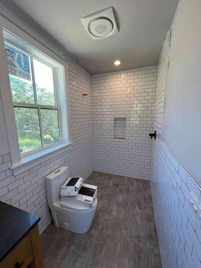 newly tiled bathroom with custom white tiles and updated energy efficient windows
